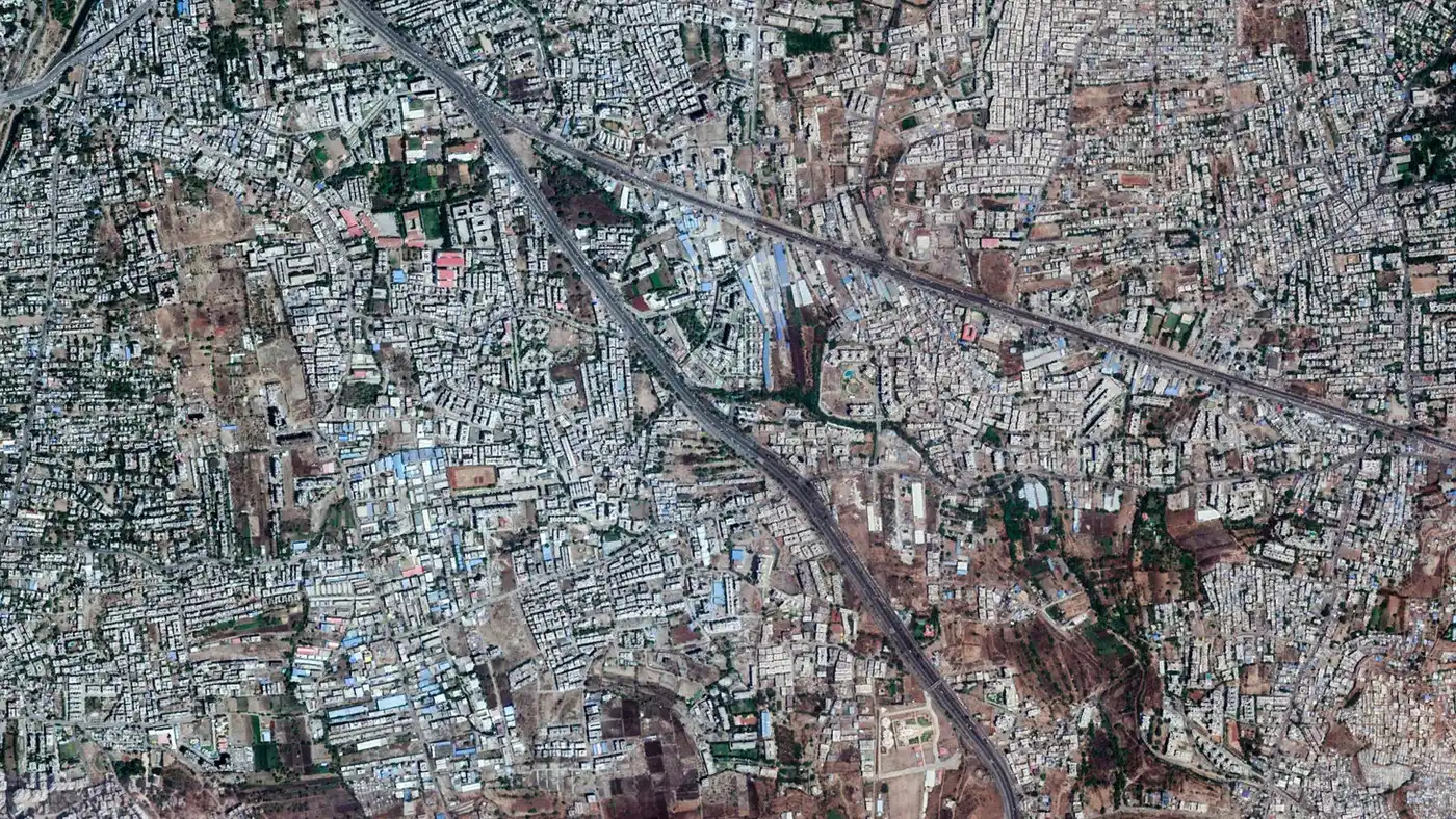 Satellite view of dense urban sprawl in Pune cut by a highway