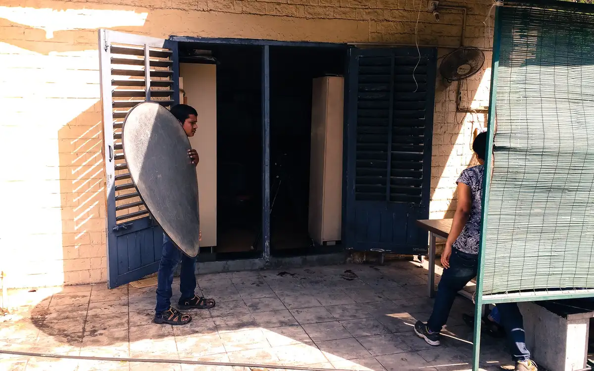 Crew member holding a reflector in a shaded doorway