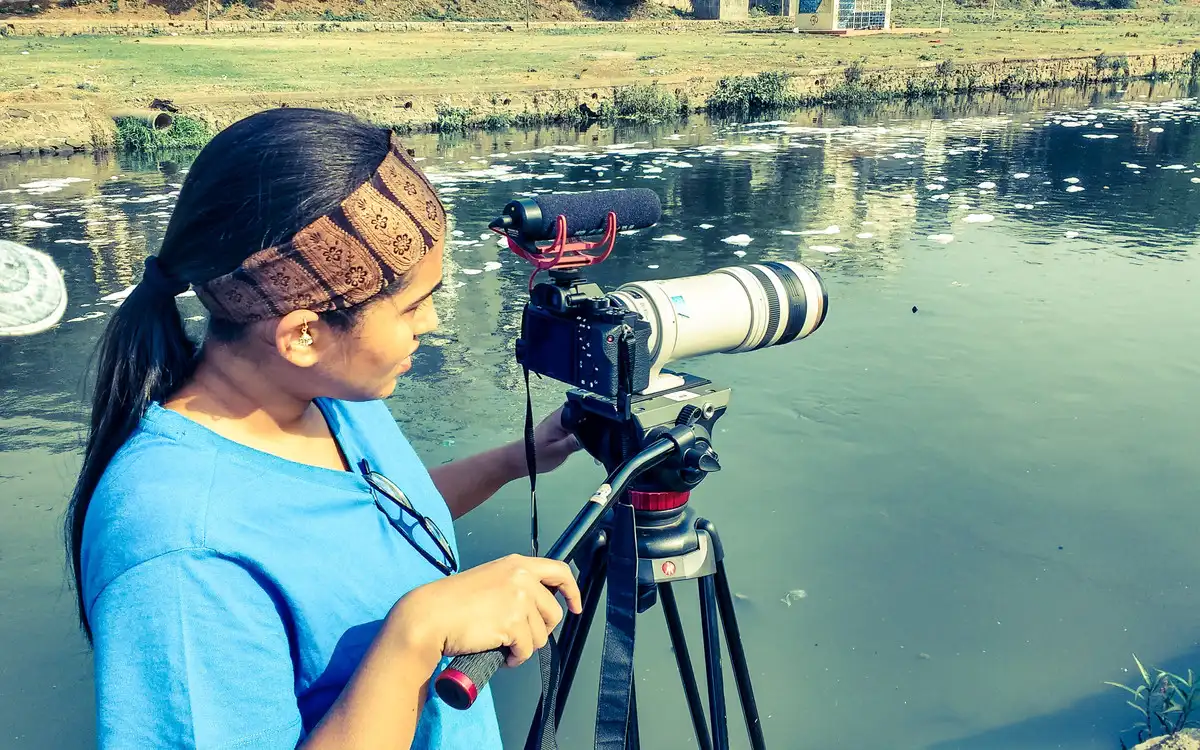 Camera operator framing a shot across a lake