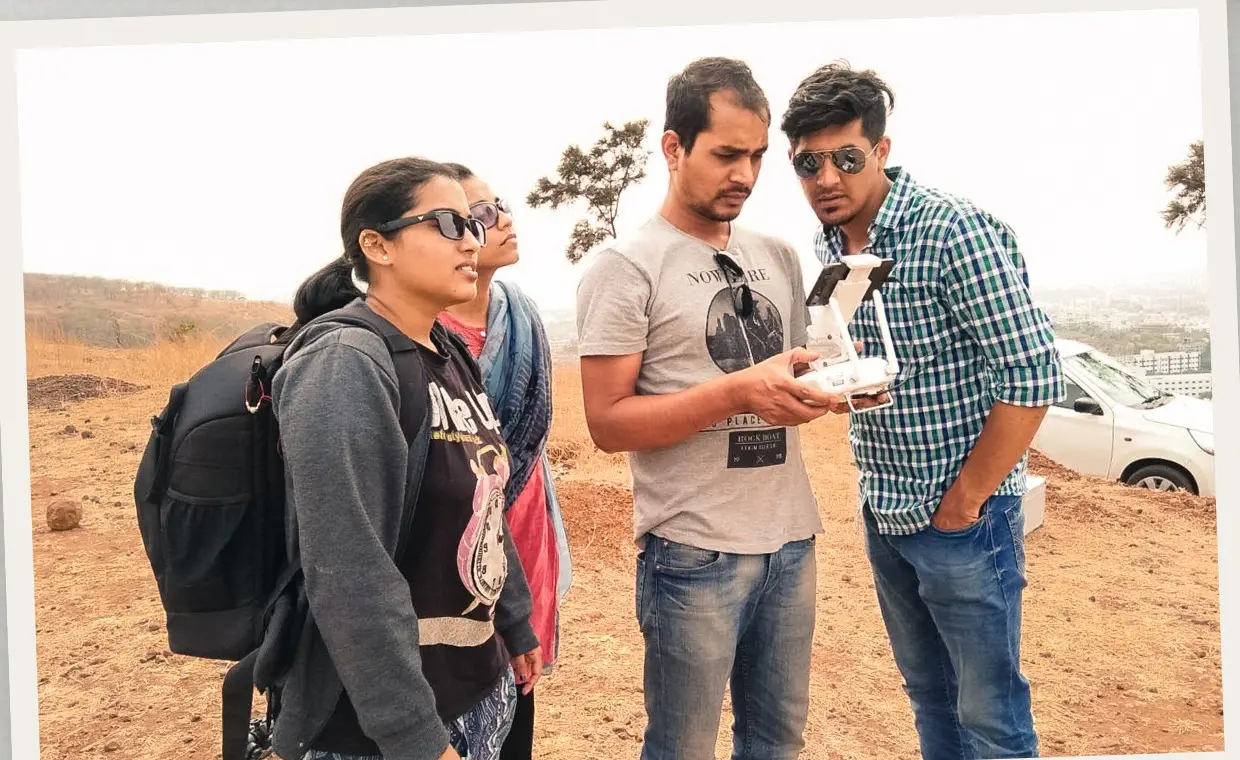 Crew checking a drone controller on an open hilltop