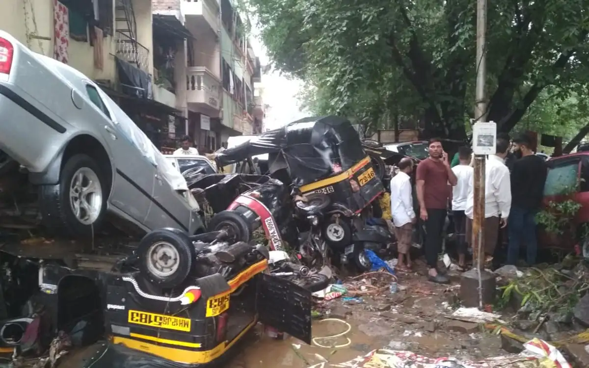 Cars and a taxi piled on top of each other after a flash flood in a residential lane